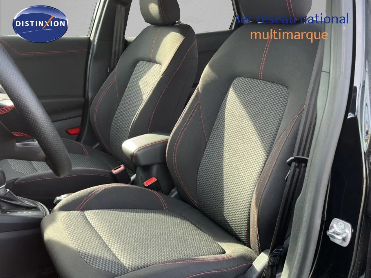 Vue intérieure des sièges avant en tissu noir avec surpiqûres rouges du Ford Puma noir agate métal 2023.