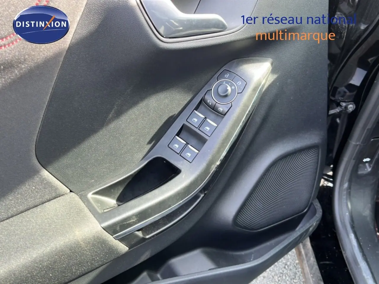Détail de la porte côté conducteur du Ford Puma noir agate métal 2023, avec commandes de vitres et haut-parleur intégré.