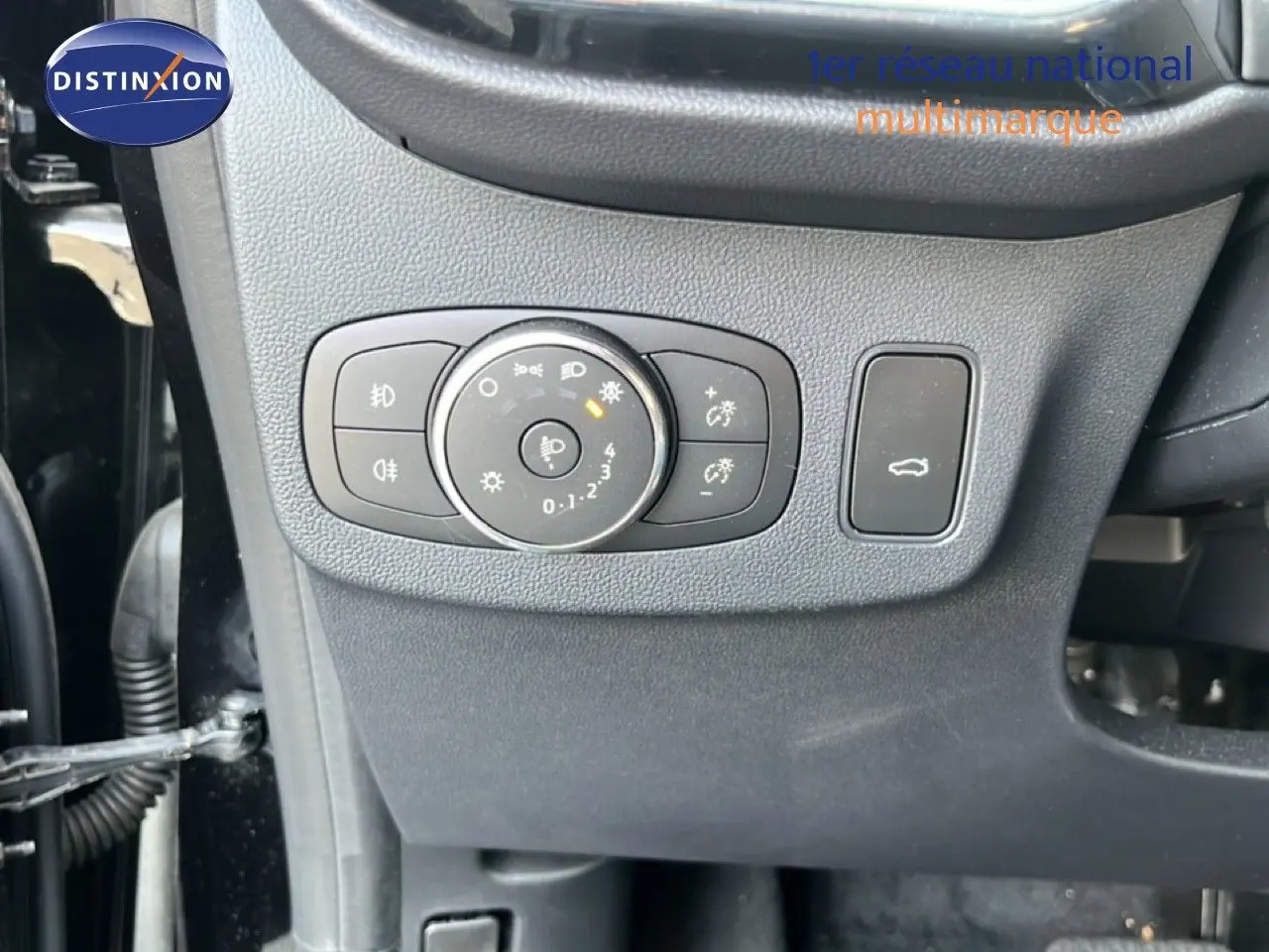 Gros plan sur les commandes d’éclairage et ouverture du coffre côté gauche d’un Ford Puma noir Agate 2023.