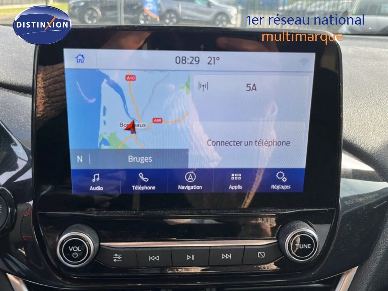 Écran tactile central du Ford Puma 2023 affichant la navigation avec carte et options multimédia, entouré de commandes noires brillantes.