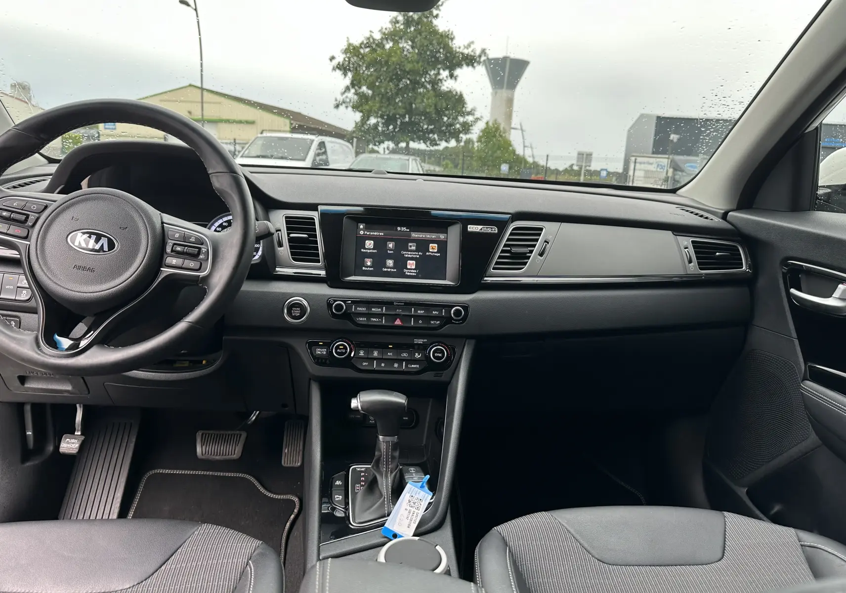 Intérieur noir du Kia Niro hybride rechargeable 2020 vu de face, avec tableau de bord et écran tactile central.