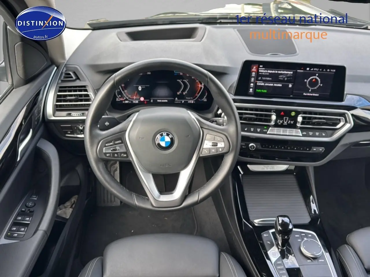Vue intérieure centrée sur le volant cuir multifonction et tableau de bord numérique du BMW X3 noir 2024