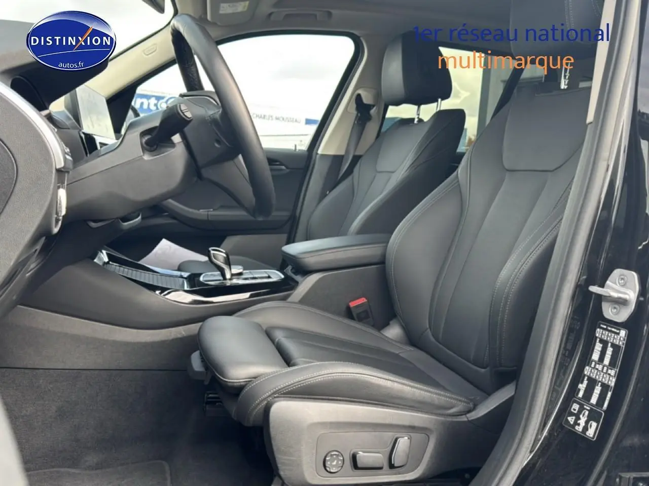 Intérieur avant droit du BMW X3 noir 2024, sièges sport en similicuir noir avec console centrale et volant cuir.