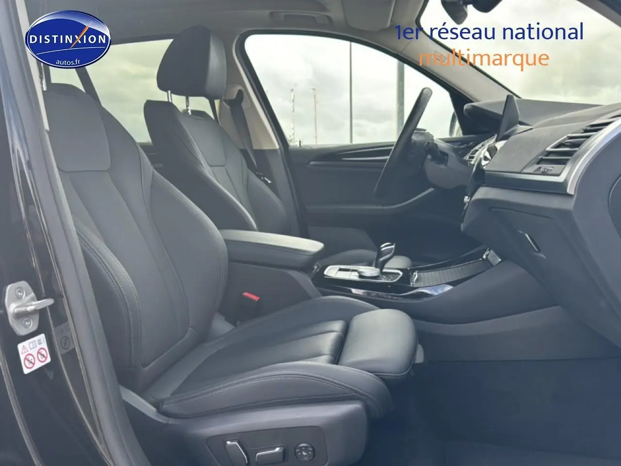 Intérieur noir de la BMW X3 2024 vu côté gauche, avec sièges sport en similicuir et console centrale moderne.