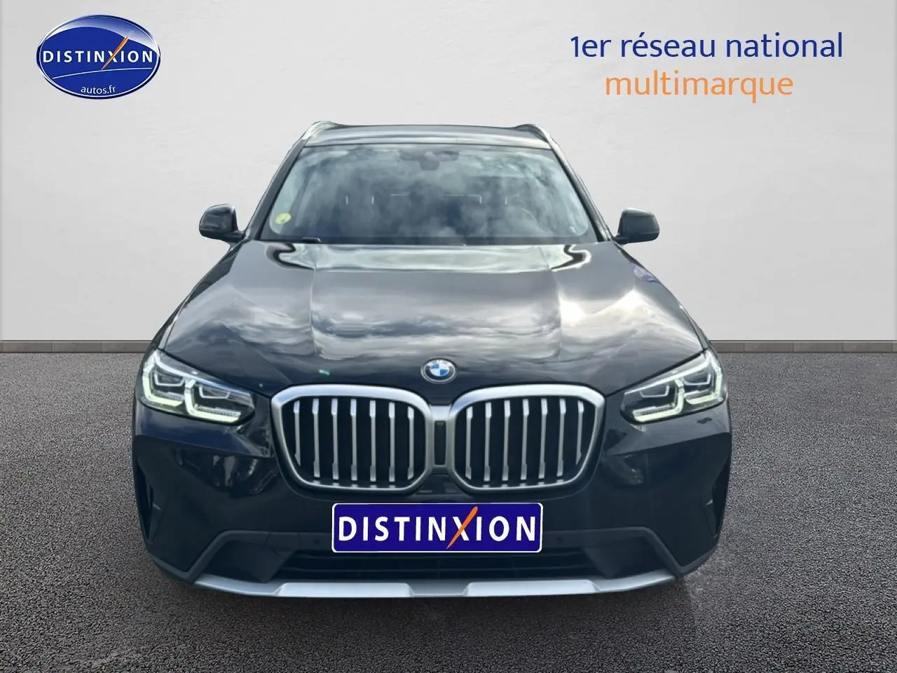 Vue frontale d'un BMW X3 noir 2024 avec calandre double haricot et phares LED allumés.