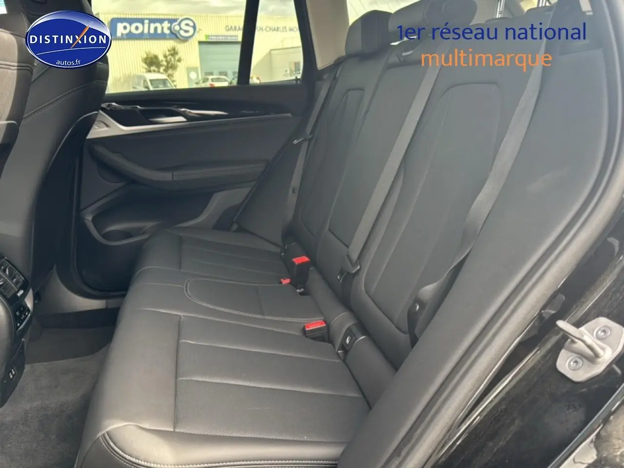 Vue intérieure côté droit des sièges arrière en similicuir noir du BMW X3 G01 xdrive20d 2024 avec ceintures grises.