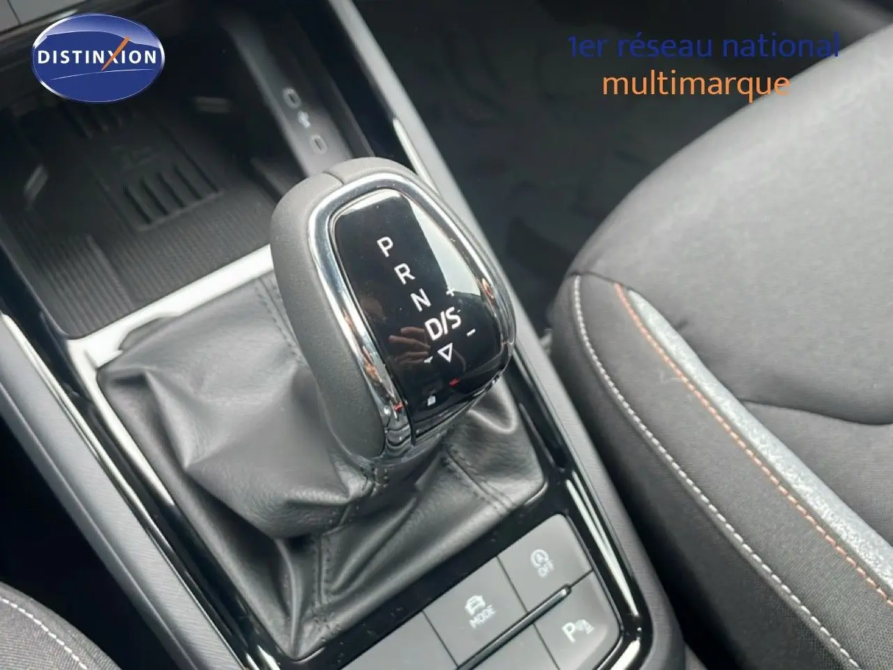 Le levier de vitesses automatique noir et chrome du Skoda Kamiq 2025, avec siège tissu gris et surpiqûres orange.