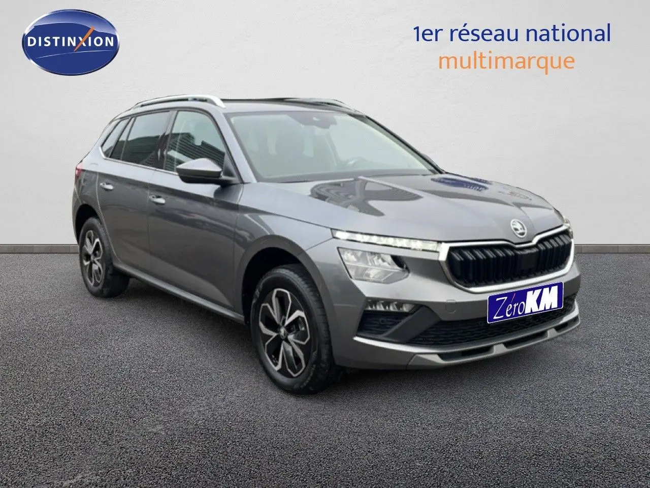 SUV Skoda Kamiq gris graphite métal vu en 3/4 avant droit avec calandre noire et jantes bicolores.
