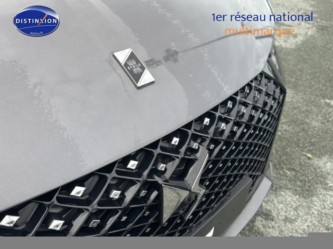 Gros plan sur la calandre noire et le capot gris platinium du DS4 Hybride 145 Pallas 2024 avec logo DS étoile.