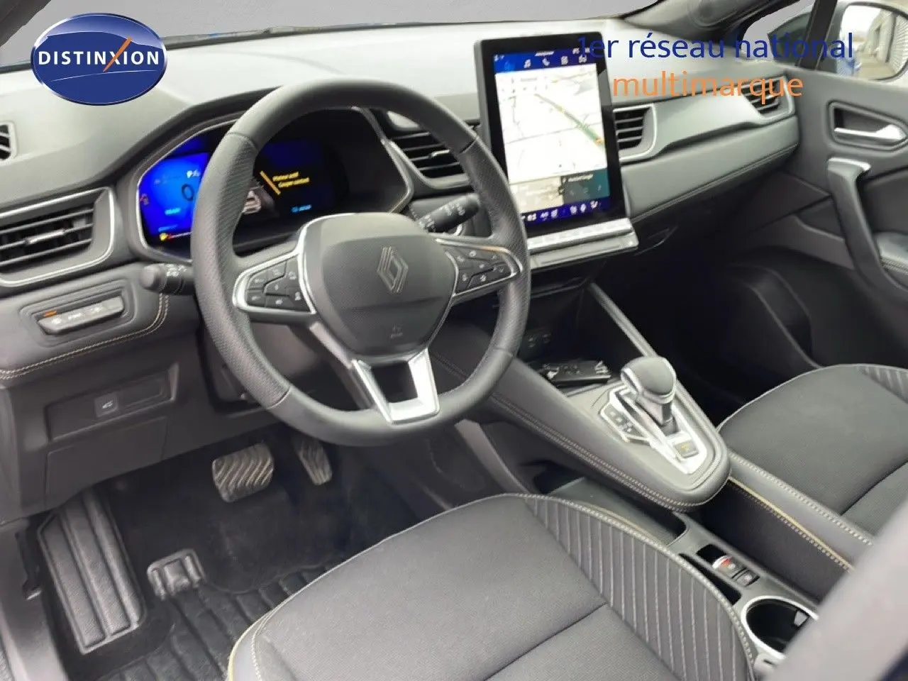 Vue intérieure côté conducteur du Renault Symbioz 2025, volant multifonction, écran tactile vertical et sellerie tissu noire.