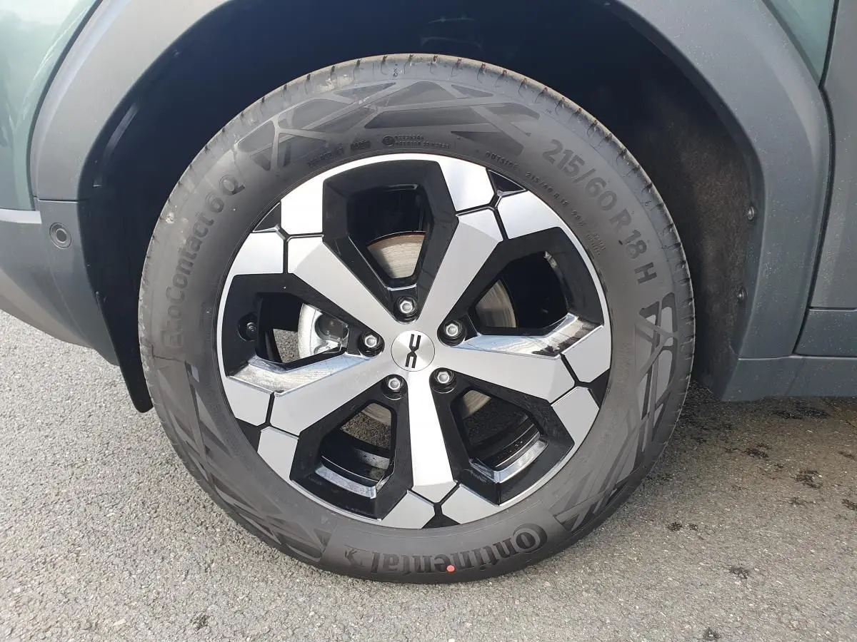 Gros plan sur la jante alliage 18” diamantée Tagasan du Dacia Duster vert cèdre, côté gauche arrière.