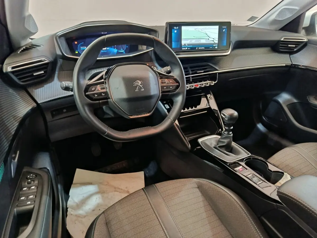 Intérieur Peugeot 208 PureTech 100 vue côté conducteur, volant cuir, écran tactile 10 pouces et boîte manuelle.