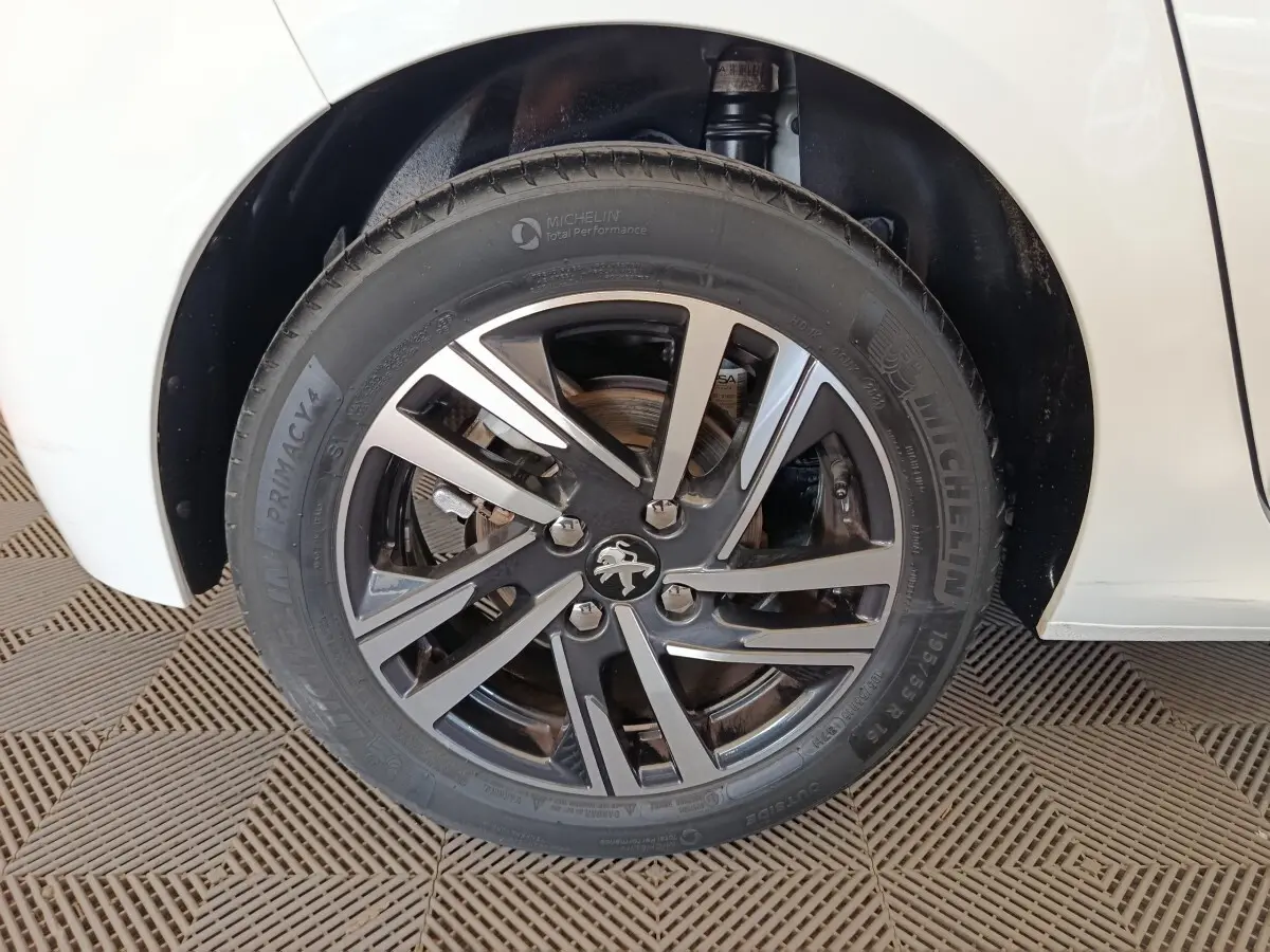 Gros plan sur la roue avant gauche de la Peugeot 208 blanche, avec jante alliage et pneu Michelin.