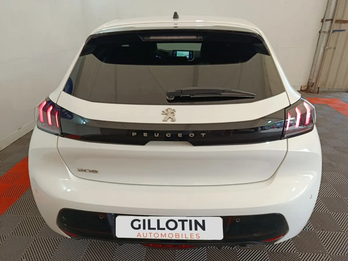 Vue arrière d'une Peugeot 208 blanche de 2021 avec feux LED caractéristiques et logo Peugeot central.