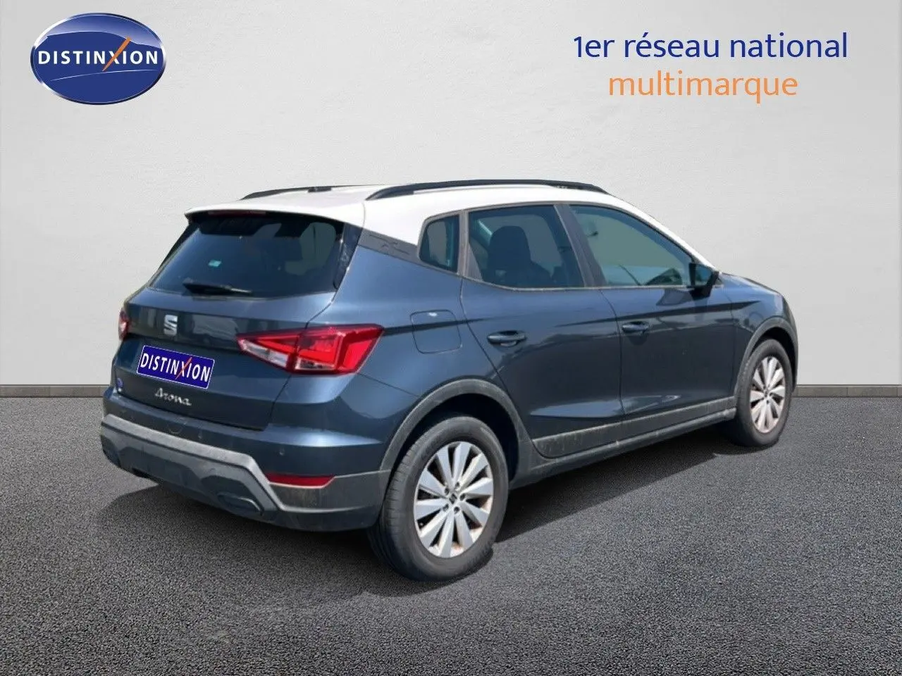 Vue 3/4 arrière droite d'une SEAT Arona gris magnetic avec toit blanc, soulignant son design compact et moderne.