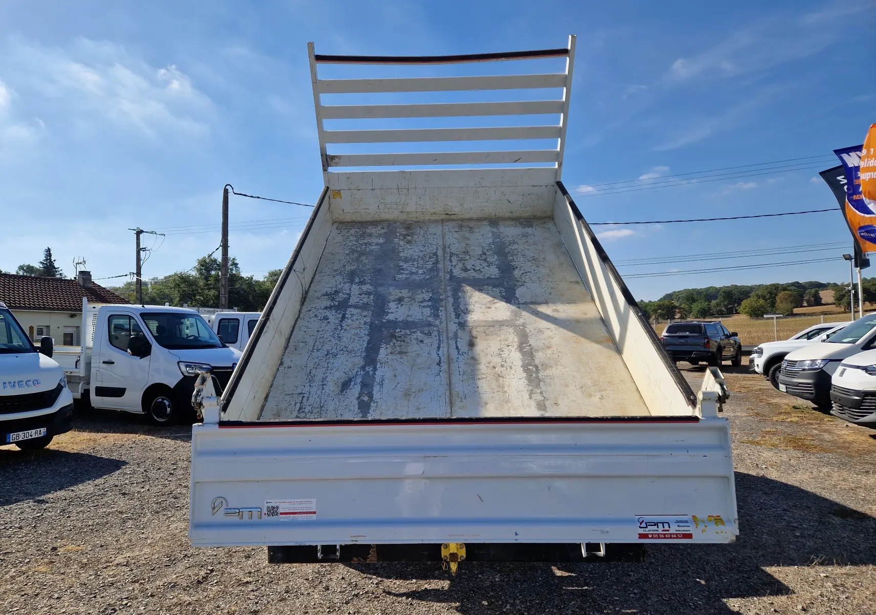Vue arrière d'une benne blanche relevée sur un Renault Master Châssis Double Cabine 2022 avec coffre et roues jumelées.