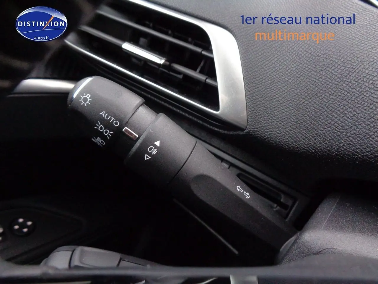 Gros plan sur la commande des feux et clignotants dans l'habitacle noir du Peugeot 3008 Gris Artense 2023.
