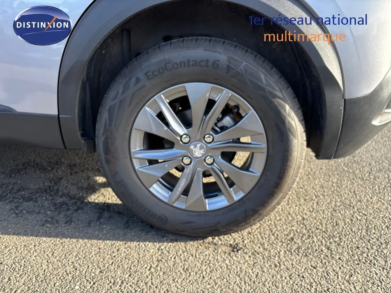 Gros plan sur la roue avant droite d'un Peugeot 2008 gris Artense avec jante alliage 16 pouces.