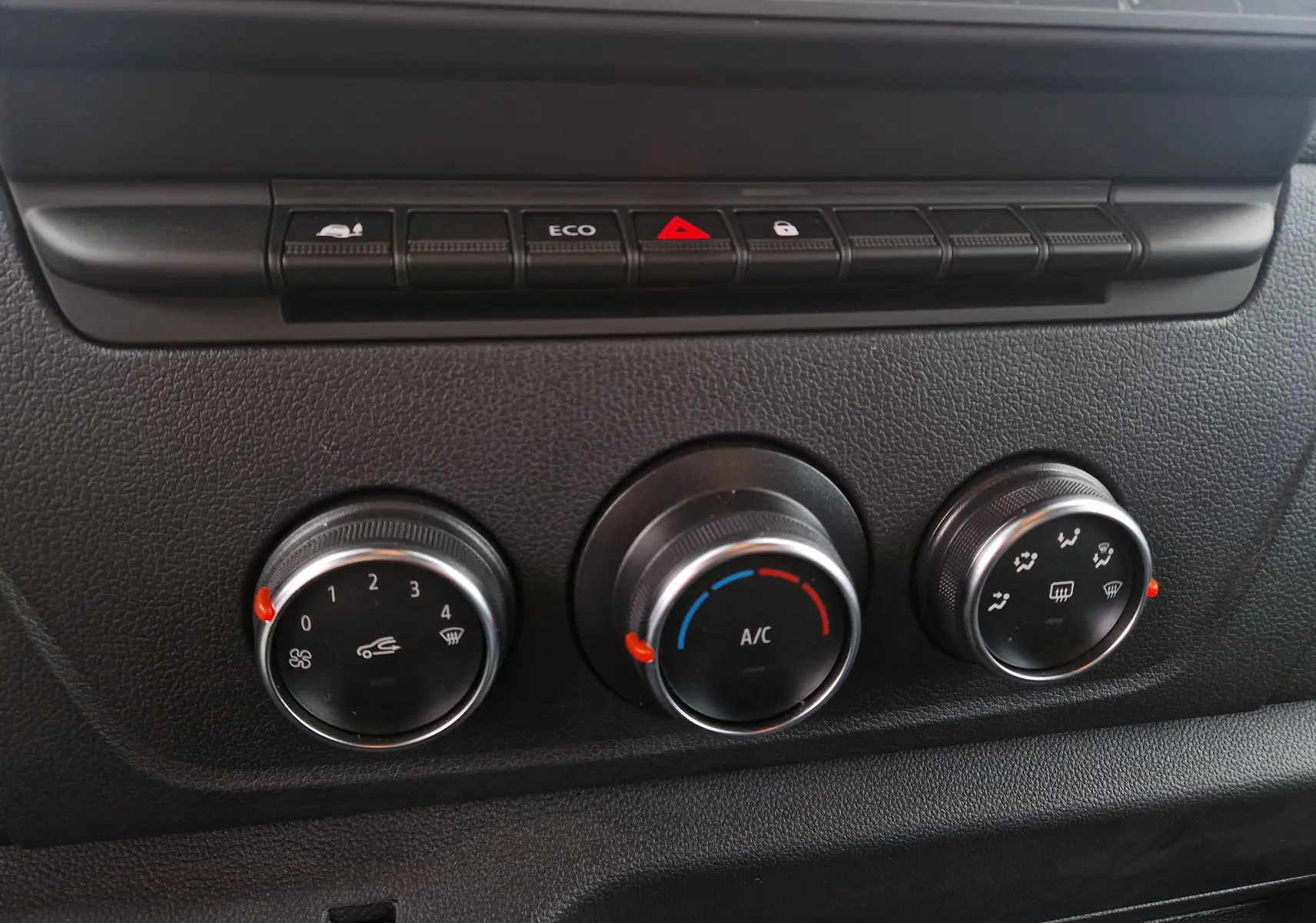 Gros plan sur les commandes de climatisation noires du tableau de bord du Renault Master blanc 2023.