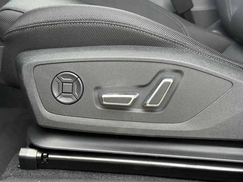 Gros plan sur les commandes de réglage électrique du siège conducteur de l'Audi Q3 2.0 TDI 150ch S line 2026 noir Mythique.
