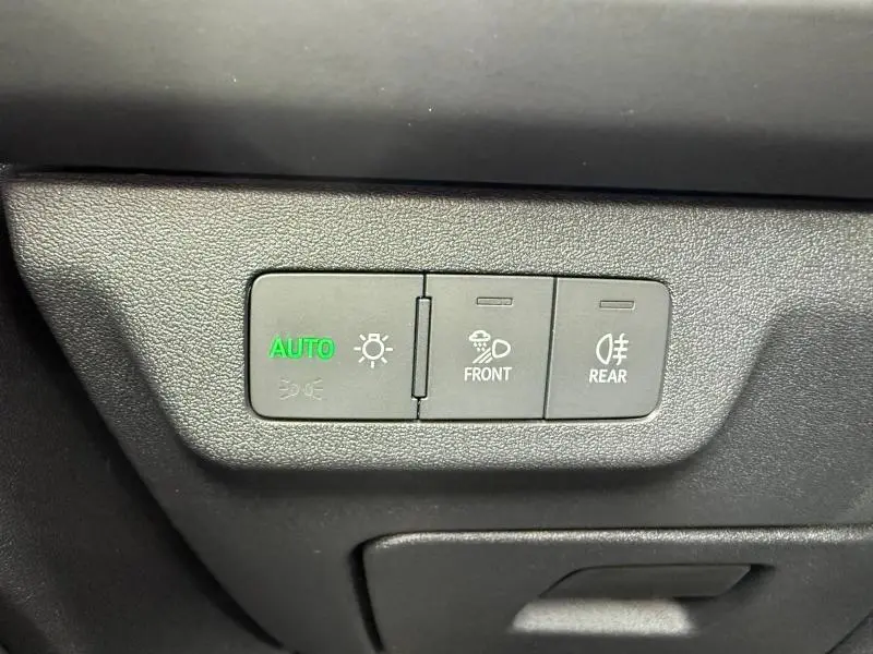 Gros plan sur les commandes d’éclairage automatique et antibrouillard avant et arrière dans un Audi Q3 noir Mythique métallisé.
