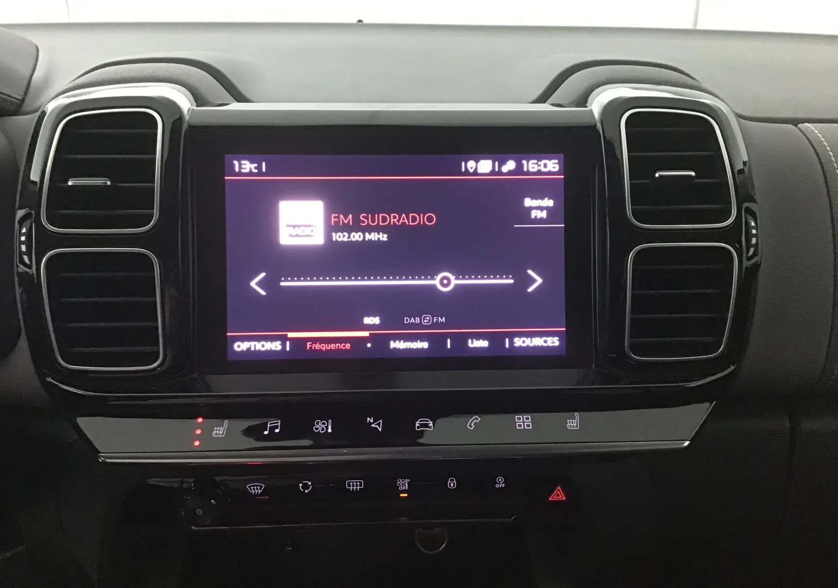 Écran tactile central allumé du Citroën C5 Aircross gris, affichant la radio FM Sudradio à 16h06, entouré de commandes noires.