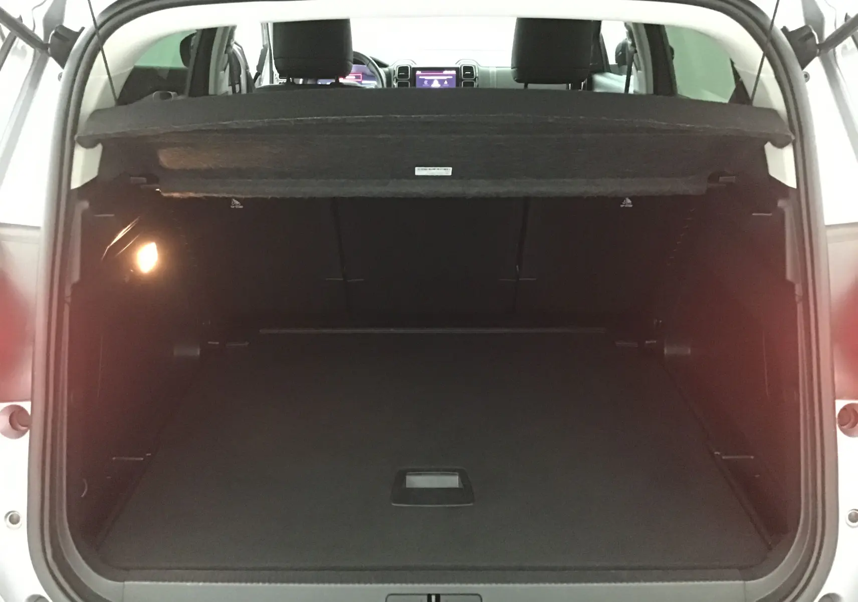 Coffre ouvert d'un Citroën C5 Aircross gris Artense vu de l'arrière, montrant l'espace de chargement vide et la tablette cache-bagages.