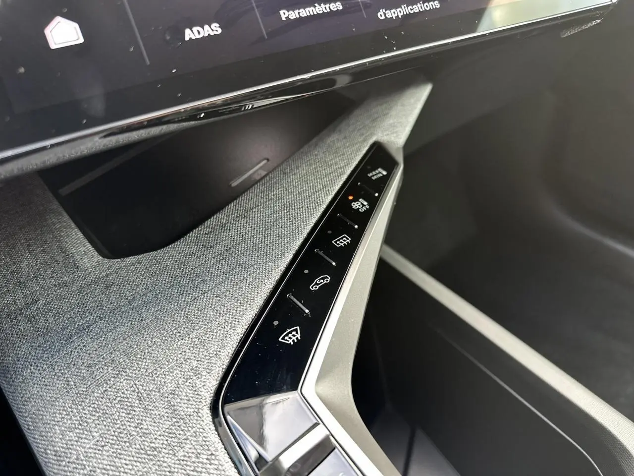 Gros plan sur la console centrale tissu gris avec commandes tactiles et écran panoramique du Peugeot 3008 Hybrid 145 Allure 2025.