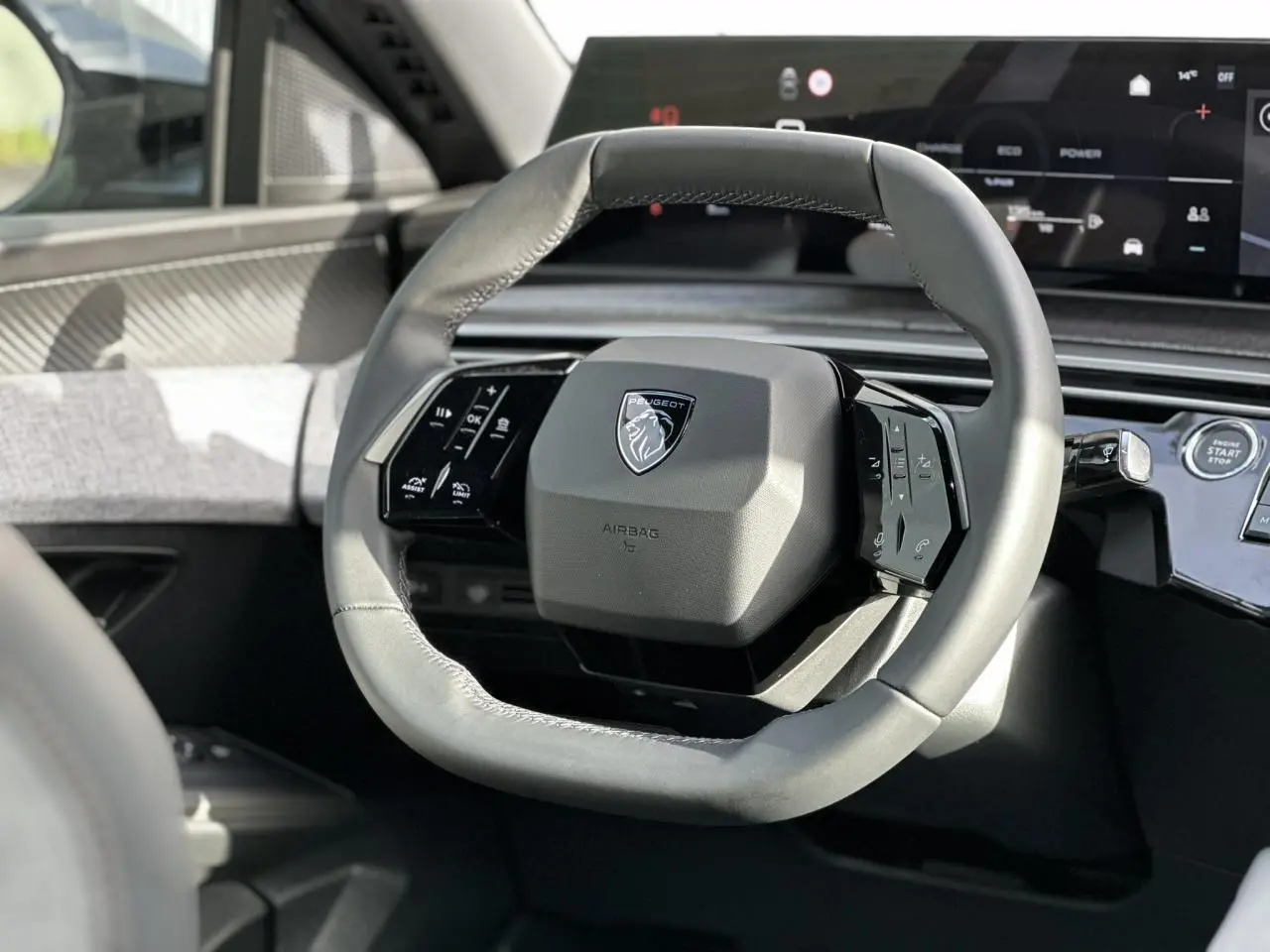 Gros plan sur le volant cuir gris du Peugeot 3008 Hybrid 2025 avec tableau de bord numérique panoramique.