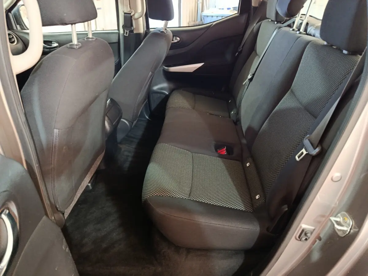 Vue intérieure arrière côté droit du Nissan Navara 2018 gris clair, montrant la banquette arrière en tissu noir et gris.
