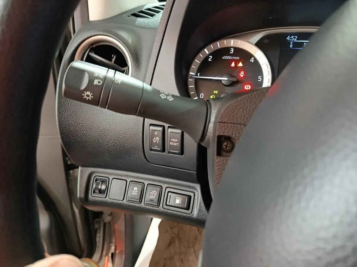 Vue rapprochée du tableau de bord côté gauche du Nissan Navara gris clair, montrant commandes et compte-tours.