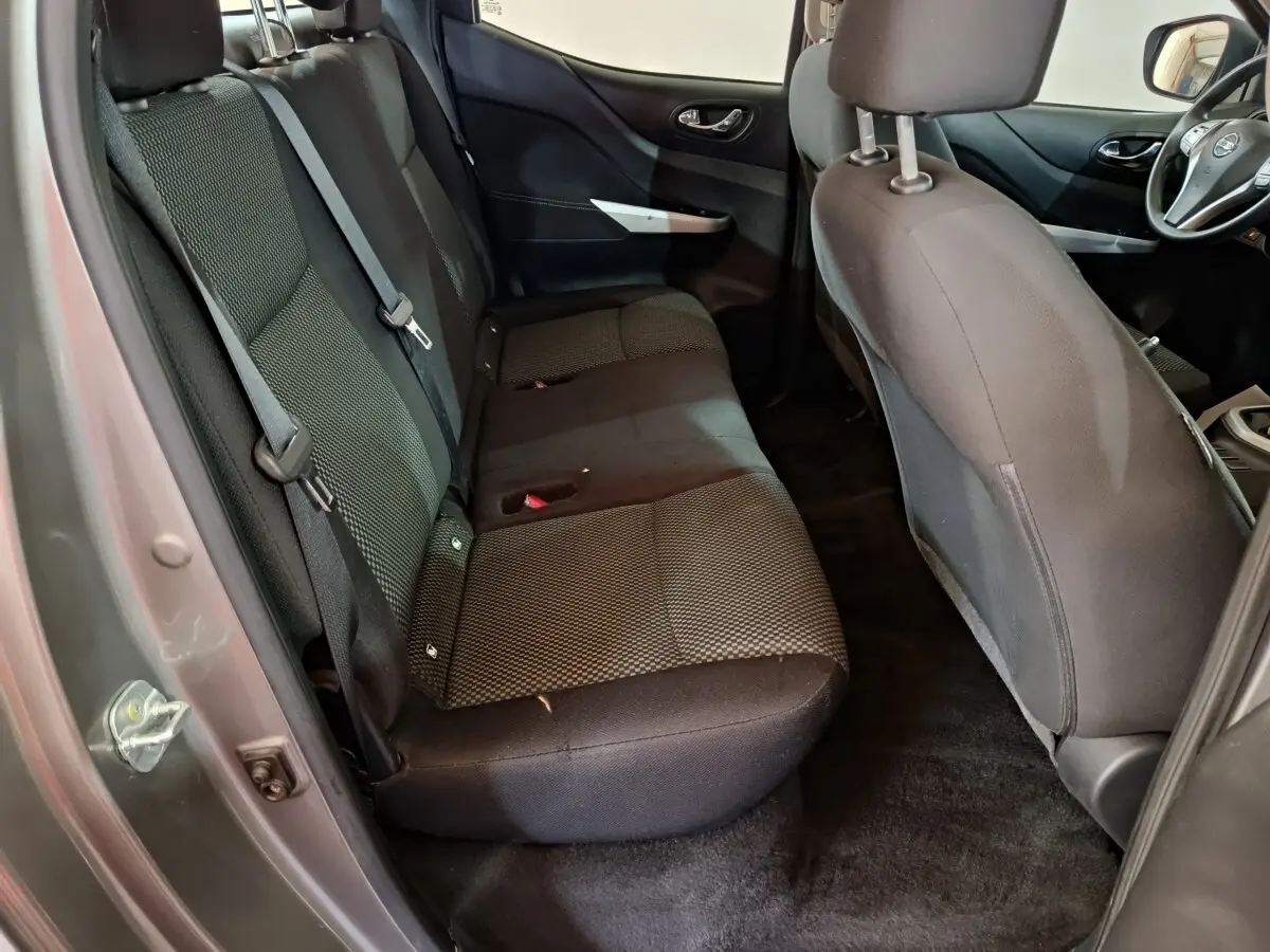 Vue intérieure côté gauche montrant la banquette arrière noire du Nissan Navara Double-Cab gris clair 2018.