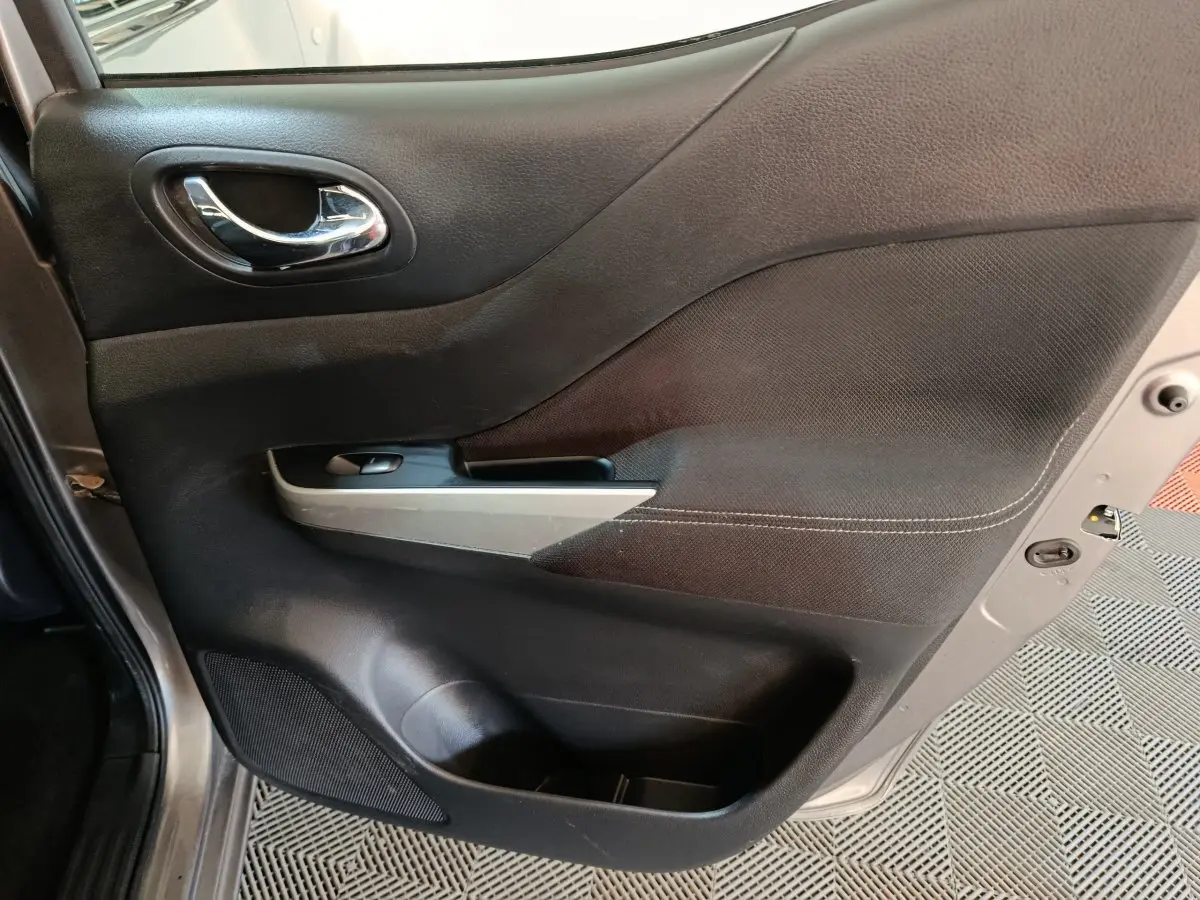 Vue rapprochée de la porte avant gauche gris clair du Nissan Navara 2018 avec poignée chrome et commande de fenêtre.