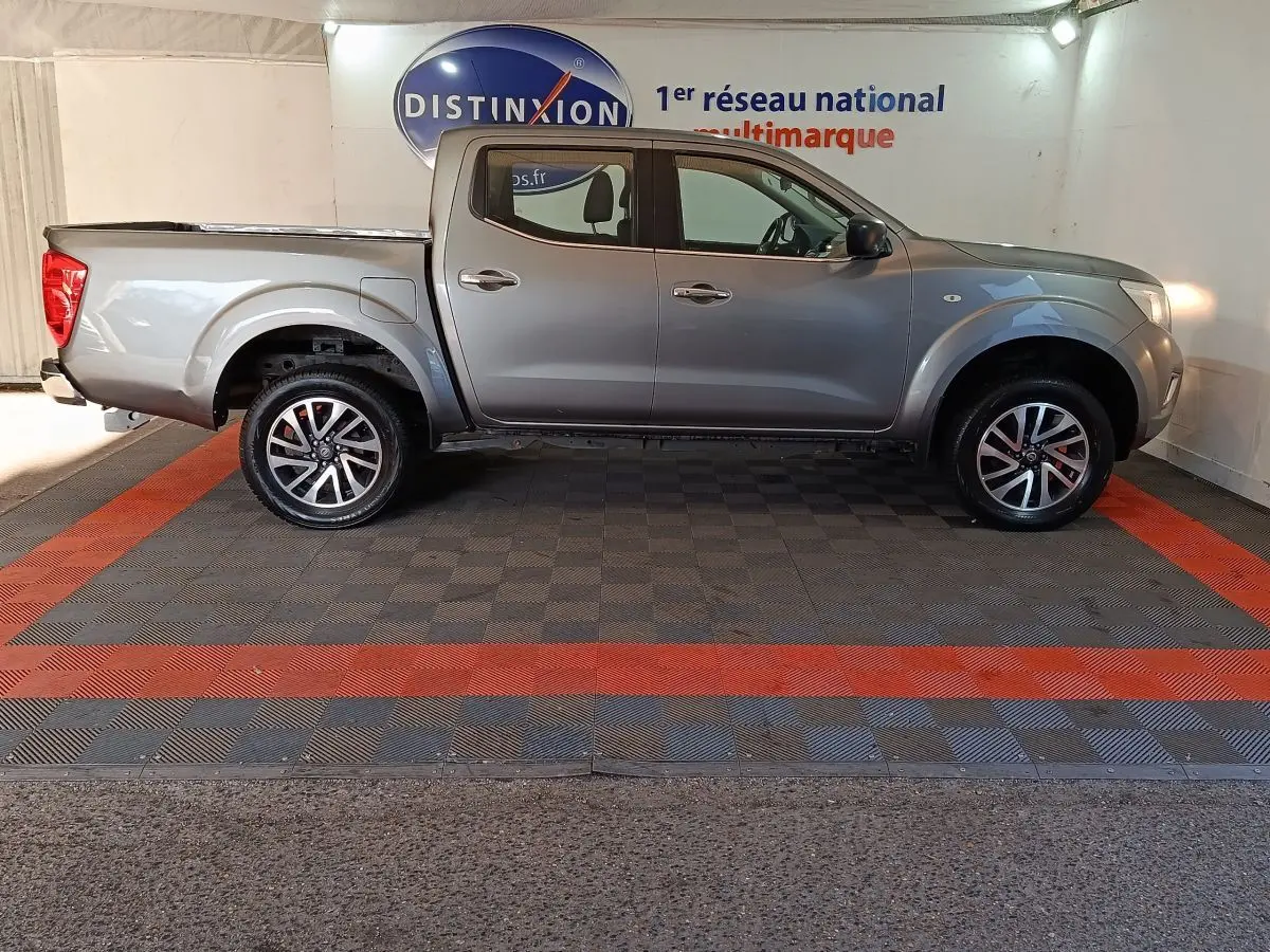 Vue de profil droit du pick-up Nissan Navara gris clair Double-Cab 2018, avec jantes alliage et benne couverte.