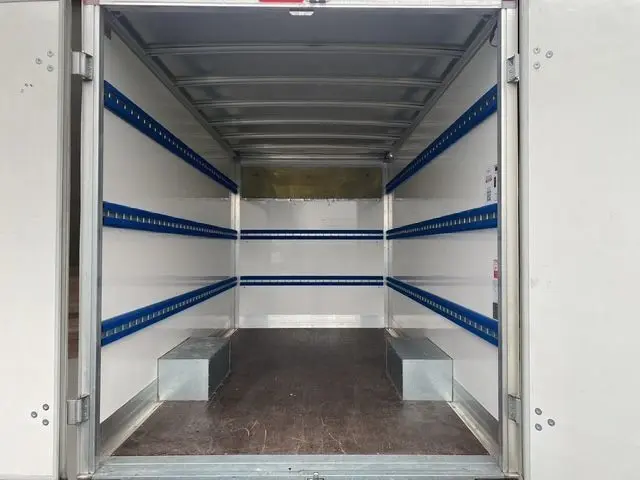 Vue intérieure arrière du Renault Master blanc 2022, montrant la caisse de chargement vide avec rails bleus sur les parois.