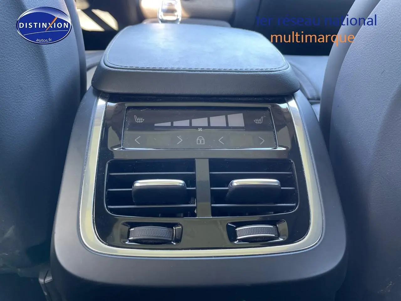 Détail de la console centrale arrière noire du Volvo XC90 2023 avec commandes de climatisation et aérateurs.