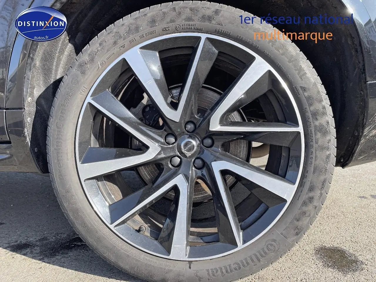 Gros plan sur la jante alu noire et argentée du côté gauche d'un Volvo XC90 noir 2023.