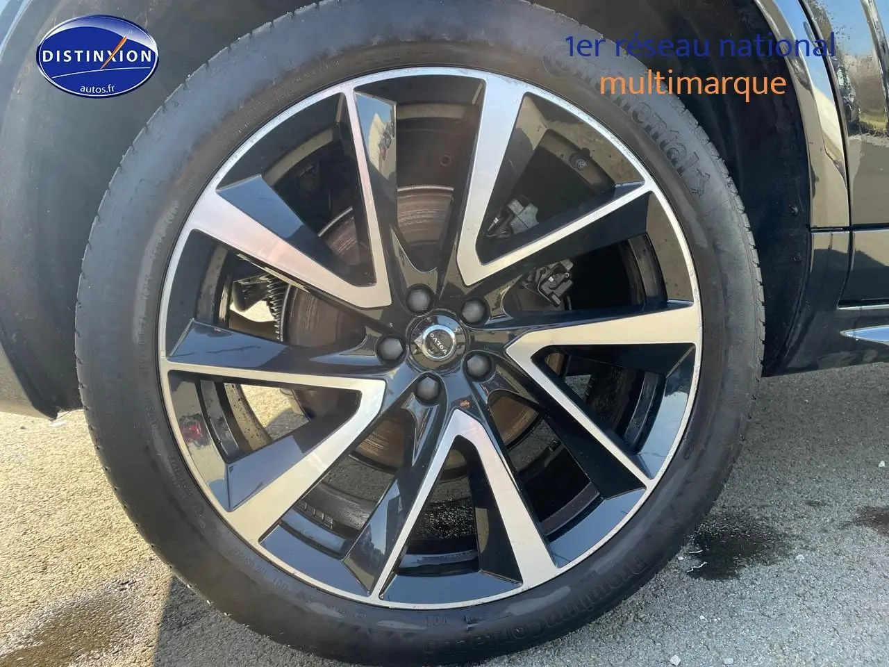 Gros plan sur la jante alu noire et argentée du côté gauche d'un Volvo XC90 noir 2023.