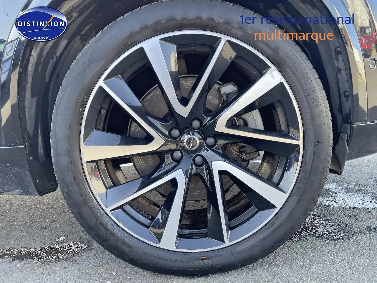 Gros plan sur la jante alu noire et argentée du côté gauche d'un Volvo XC90 noir 2023.