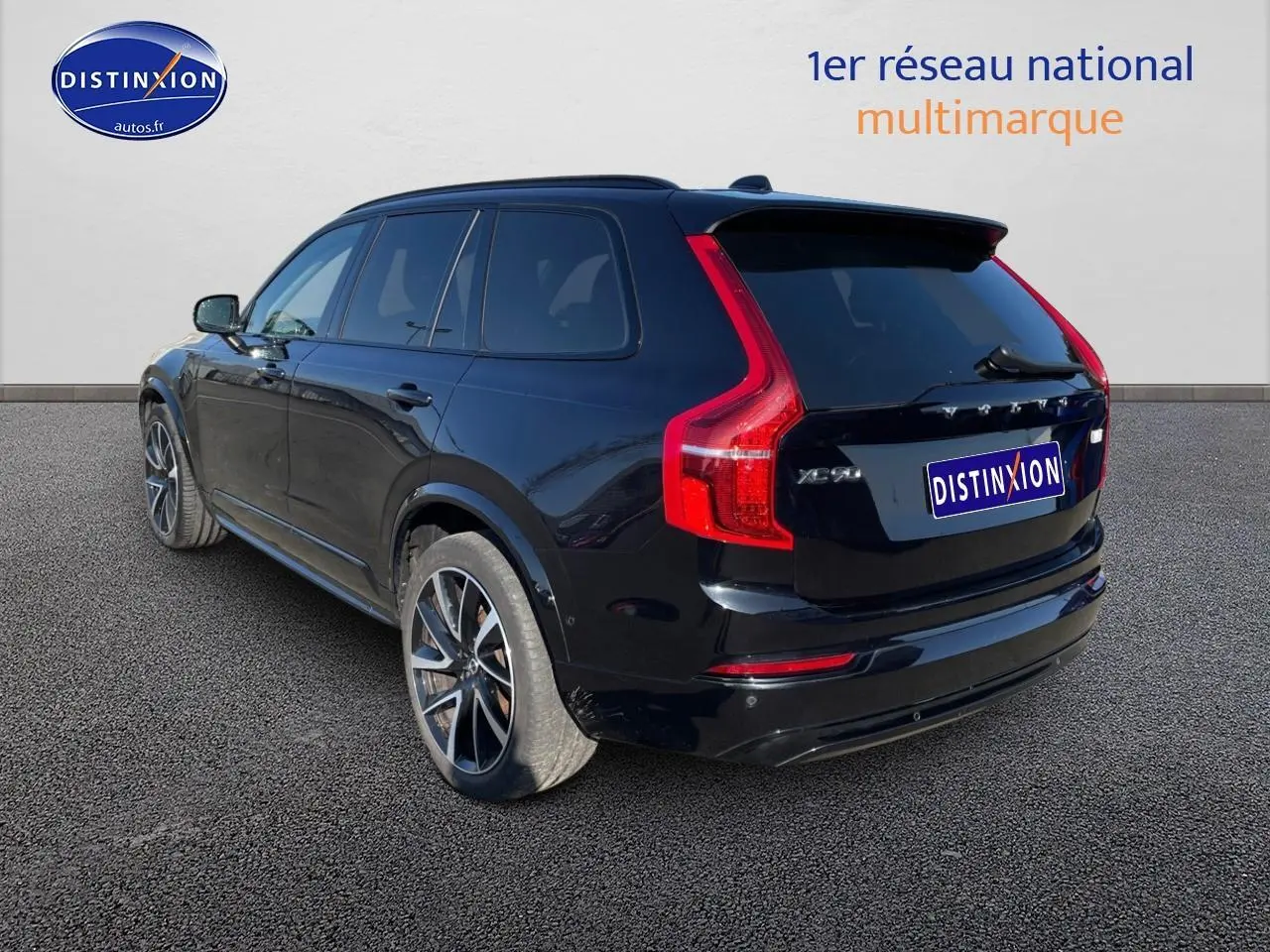 Vue 3/4 arrière droite d'un Volvo XC90 noir avec feux arrière en forme de L et jantes alliage.