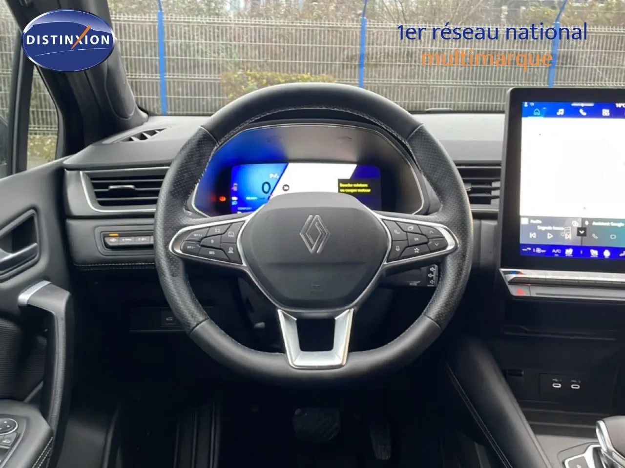 Vue intérieure centrée sur le volant noir du Renault Symbioz 2025 avec tableau de bord numérique et écran tactile.