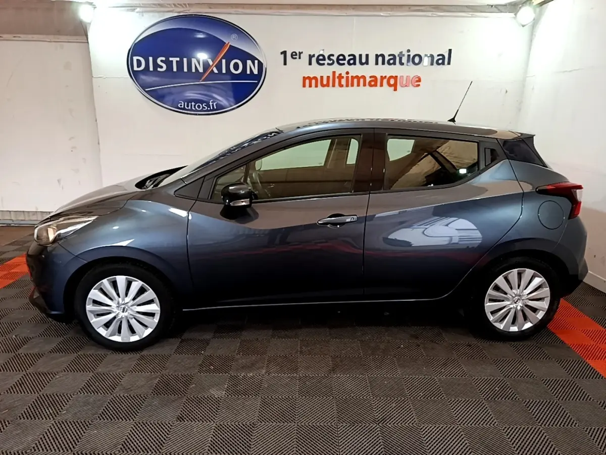 Profil droit d'une Nissan Micra IG-T 100 Business Edition gris foncé, en intérieur avec jantes alliage et rétroviseurs noirs.