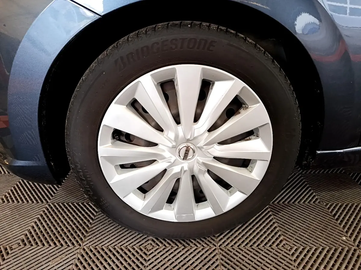 Gros plan sur la roue avant gauche d'une Nissan Micra gris foncé avec jante en alliage argenté et pneu Bridgestone.