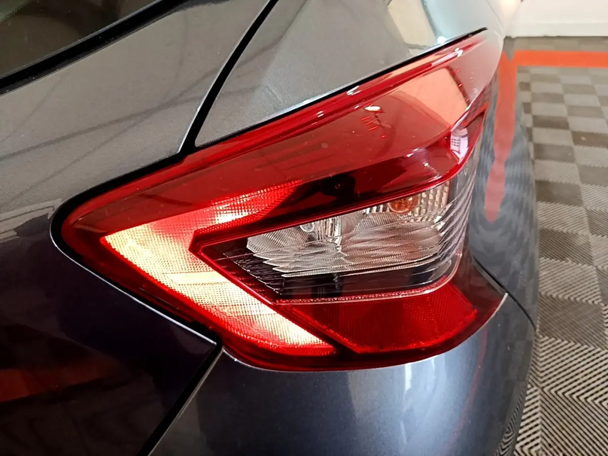 Gros plan sur le feu arrière droit rouge d'une Nissan Micra IG-T 100 Business Edition gris foncé 2020.