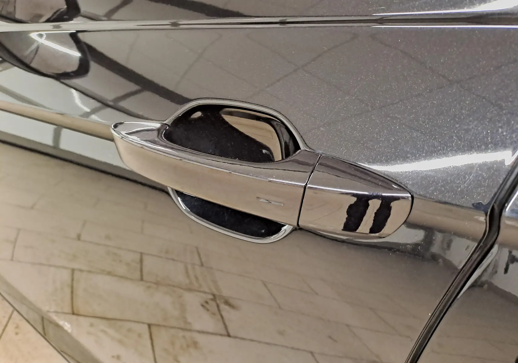 Gros plan sur la poignée de porte côté gauche du Volkswagen Taigo noir intense nacré avec finition brillante.