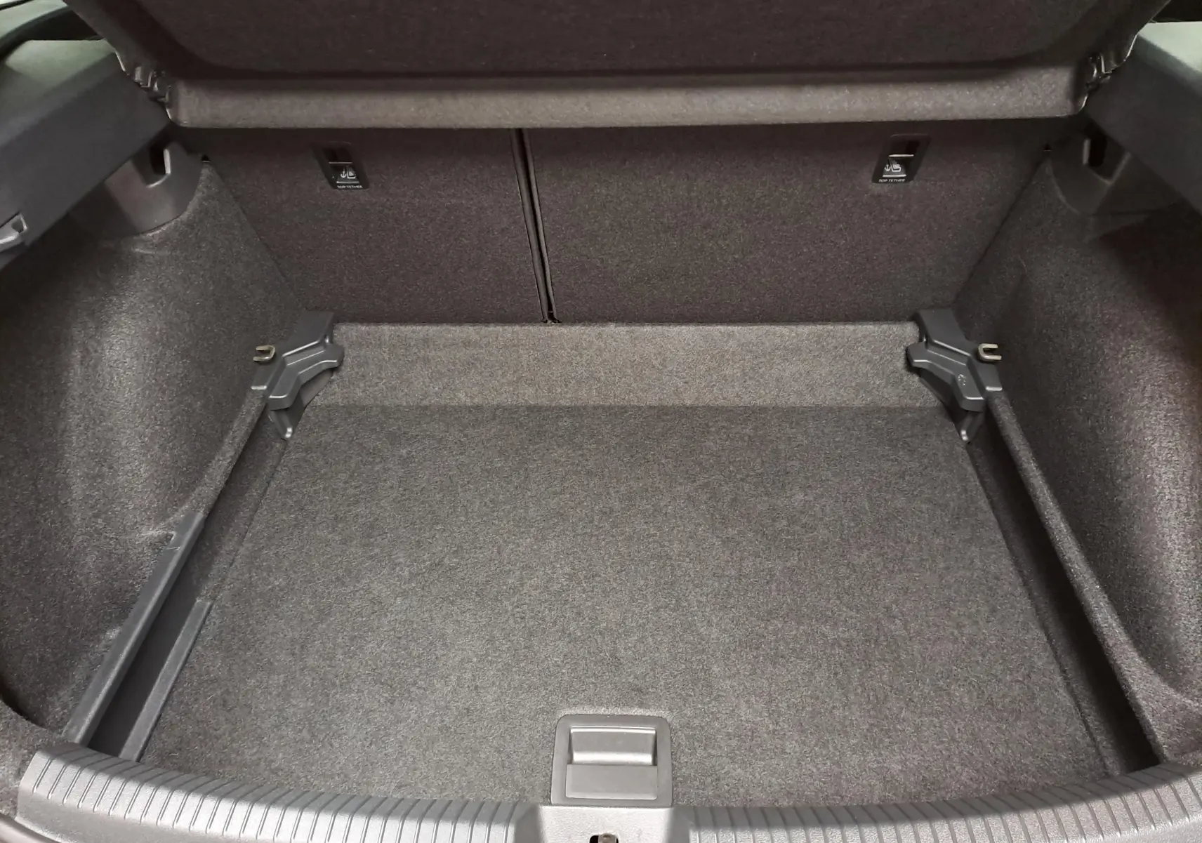 Coffre vide en vue plongeante du Volkswagen Taigo 1.5 TSI 150 DSG7 R-Line Edition, revêtement gris foncé.