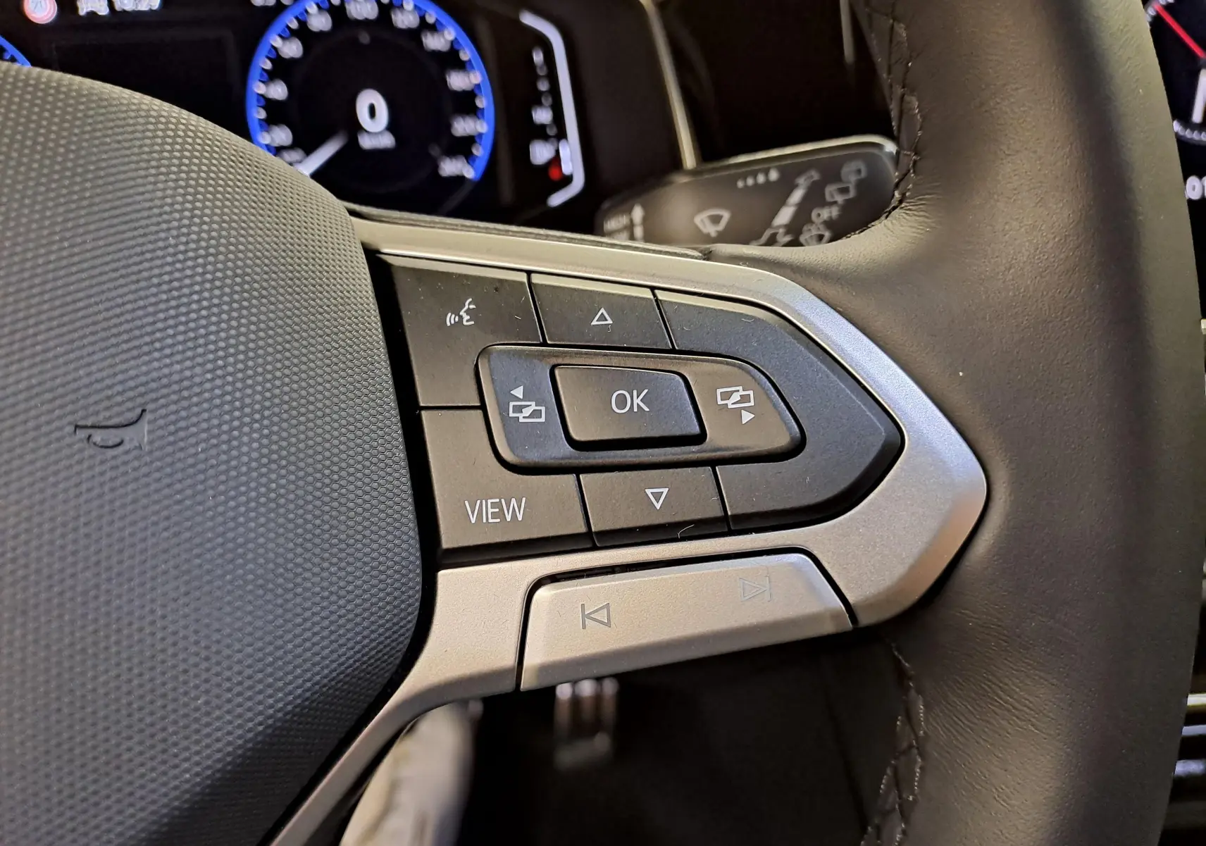 Gros plan sur les commandes gauche du volant cuir noir du Volkswagen Taigo 1.5 TSI 150 DSG7 R-Line Edition 2025.