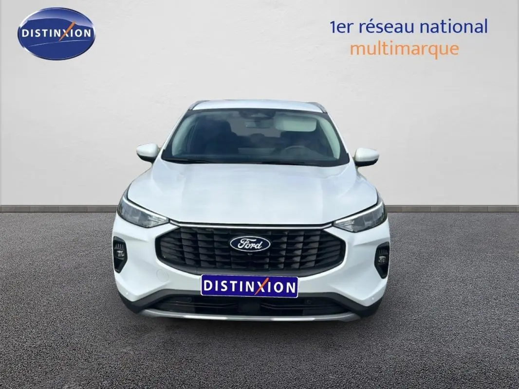 Vue avant d'un Ford Kuga blanc 2025 avec calandre noire et barres de toit visibles sur fond neutre.