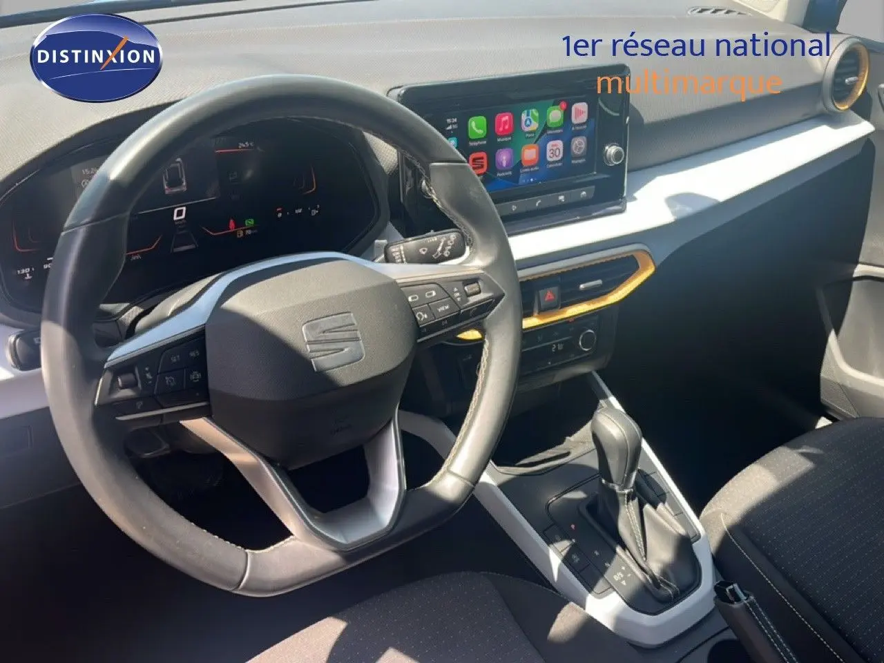 Vue intérieure centrée sur le volant et la console centrale du SEAT Arona 2025 avec écran tactile et sellerie noire.