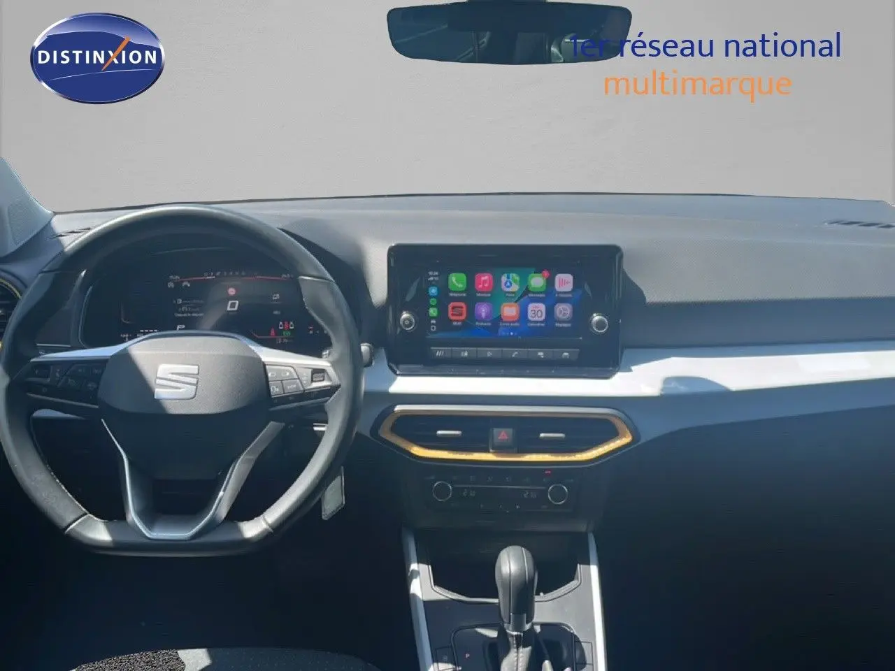 Vue intérieure frontale du tableau de bord du SEAT Arona bleu saphir, avec écran tactile et volant multifonction.